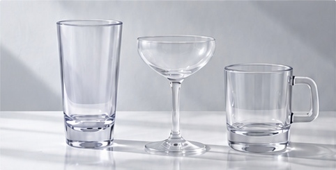Clear tumbler, coupe and handled mug on a marble surface